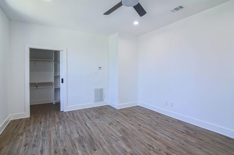 Unfurnished bedroom with a closet, wood-type flooring, and ceiling fan