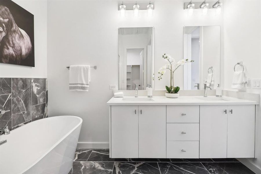 Bathroom featuring tile patterned flooring, a washtub, and double sink vanity