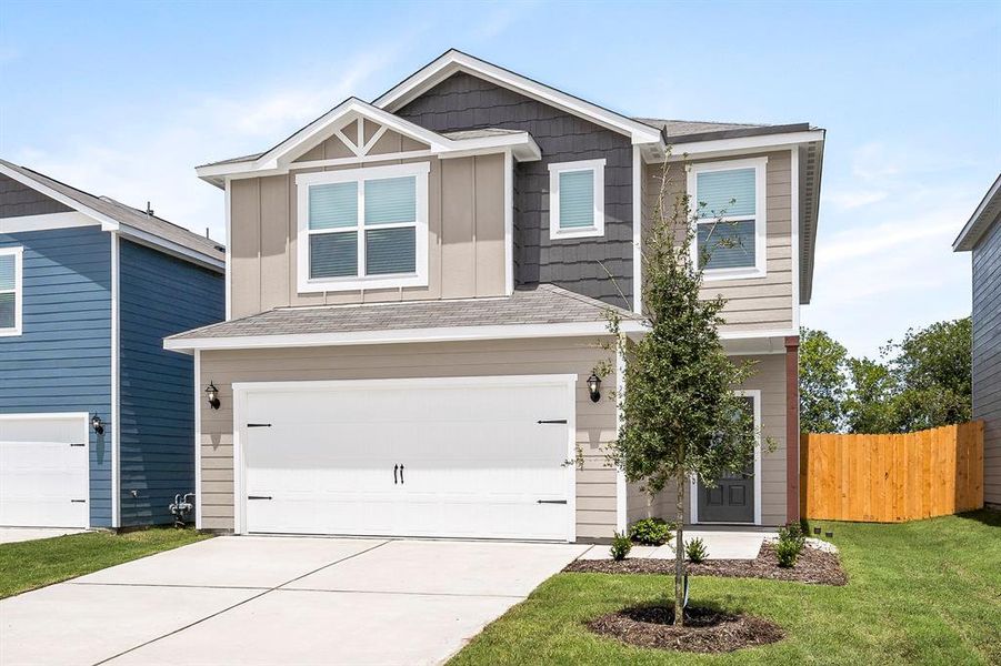 View of front of home featuring a front yard and a garage