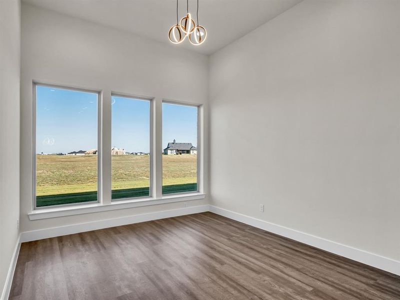 Spare room featuring hardwood / wood-style flooring and a chandelier