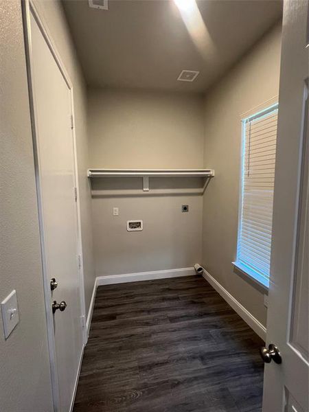 Washroom with dark hardwood / wood-style flooring and electric dryer hookup