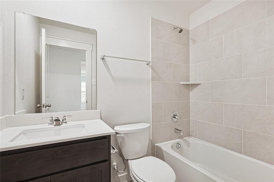 Full bathroom featuring vanity, toilet, and tiled shower / bath