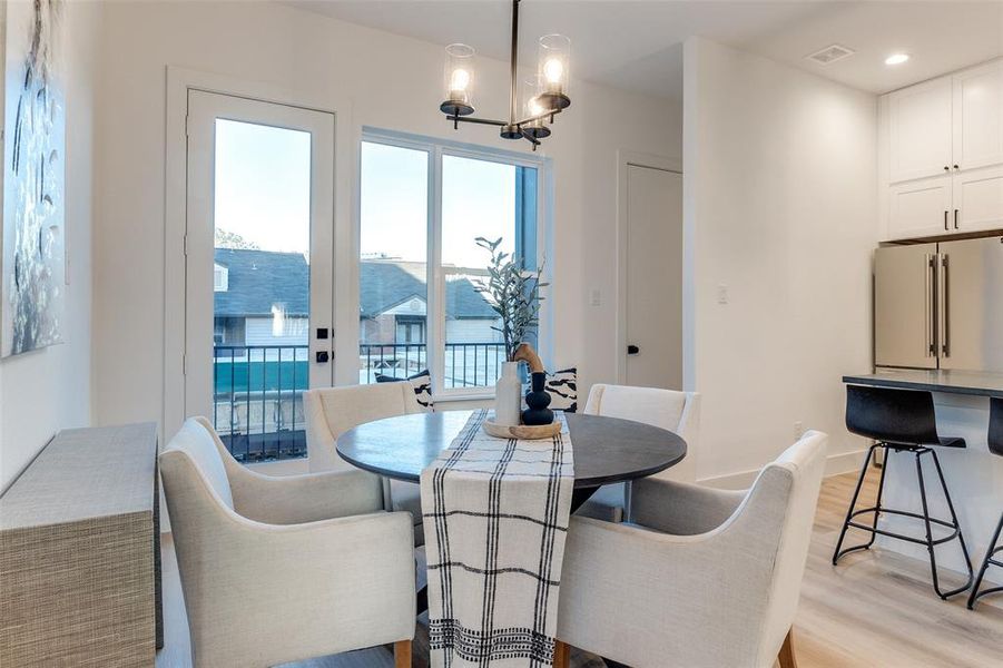 Dining space with a notable chandelier and light wood-type flooring