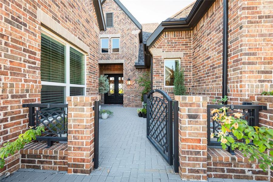 View of front courtyard leads to iron french doors