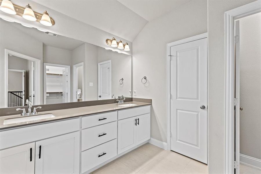 Bathroom featuring vanity, vaulted ceiling, and tile patterned floors