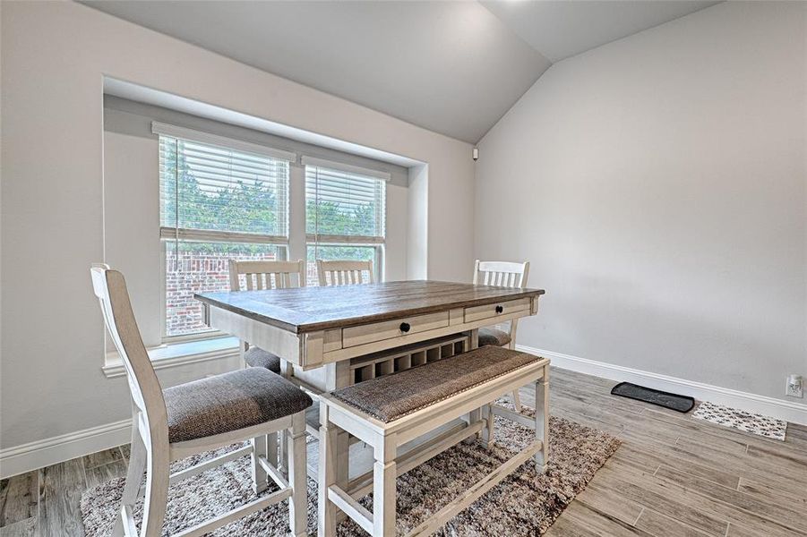 Dining space featuring light hardwood / wood-style flooring and lofted ceiling