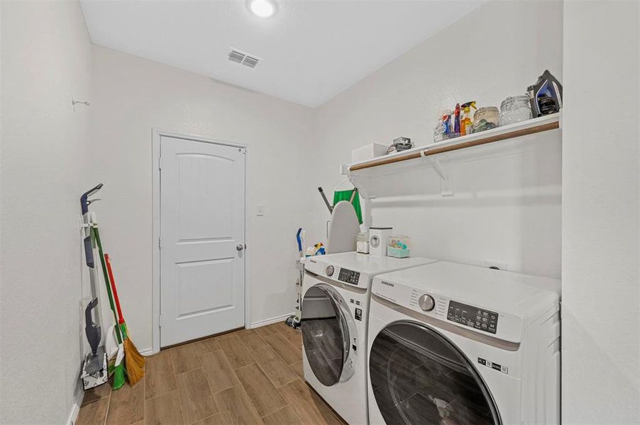 Clothes washing area featuring light hardwood / wood-style floors and washing machine and dryer