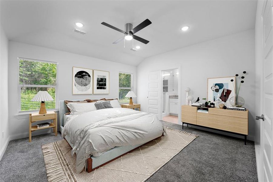 Staged owners bedroom featuring connected bathroom, vaulted ceiling, and ceiling fan