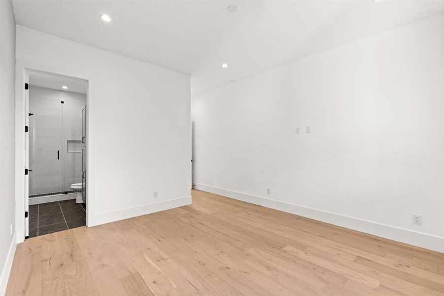 Spacious Secondary Bedroom with handsome hardwood flooring, tons of natural lighting from wall of windows and en suite bathroom.