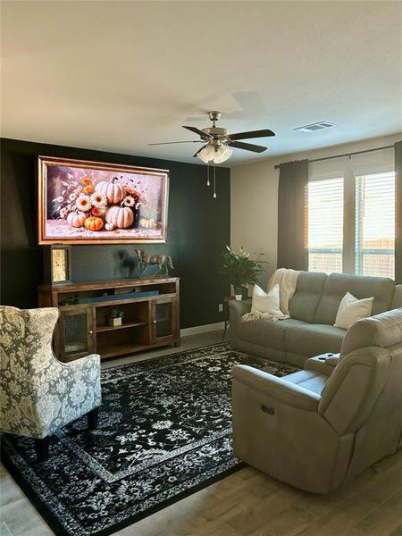 Living room with hardwood / wood-style flooring and ceiling fan