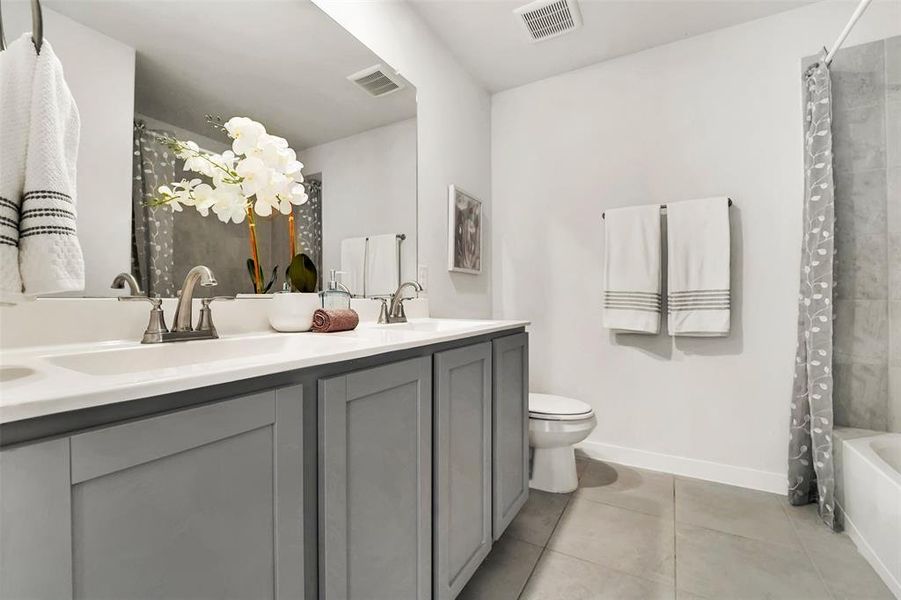 Full bathroom featuring tile patterned floors, shower / bath combination with curtain, toilet, and vanity