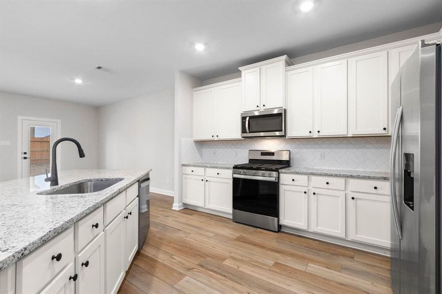 The kitchen comes with stainless steel Whirlpool appliances and a large, island.