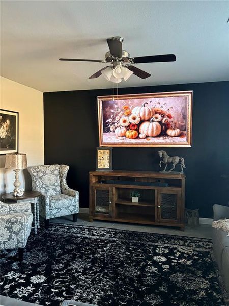 Carpeted living room with ceiling fan