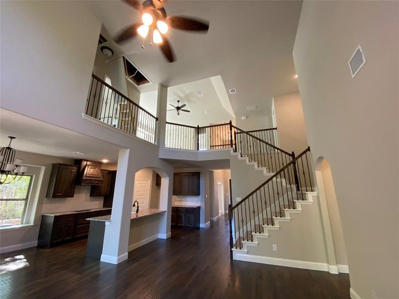 Impressive cathedral ceiling in family room with wrought iron spindles on stair