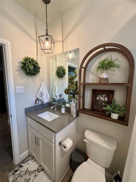 Bathroom featuring hardwood / wood-style flooring, vanity, and toilet