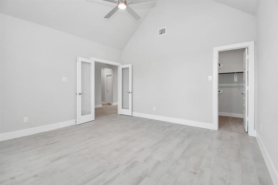 Experience the perfect blend of sophistication and warmth in this home office, boasting elegant wood-look tile flooring and flooded with natural light from expansive windows and French doors.