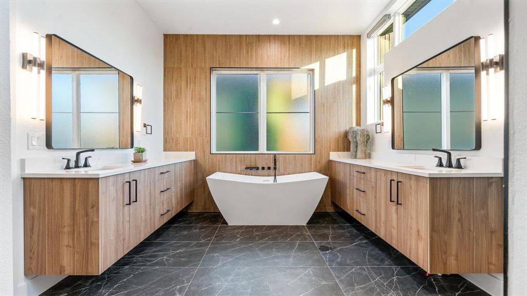 Bathroom with a bath, double vanity, and tile floors