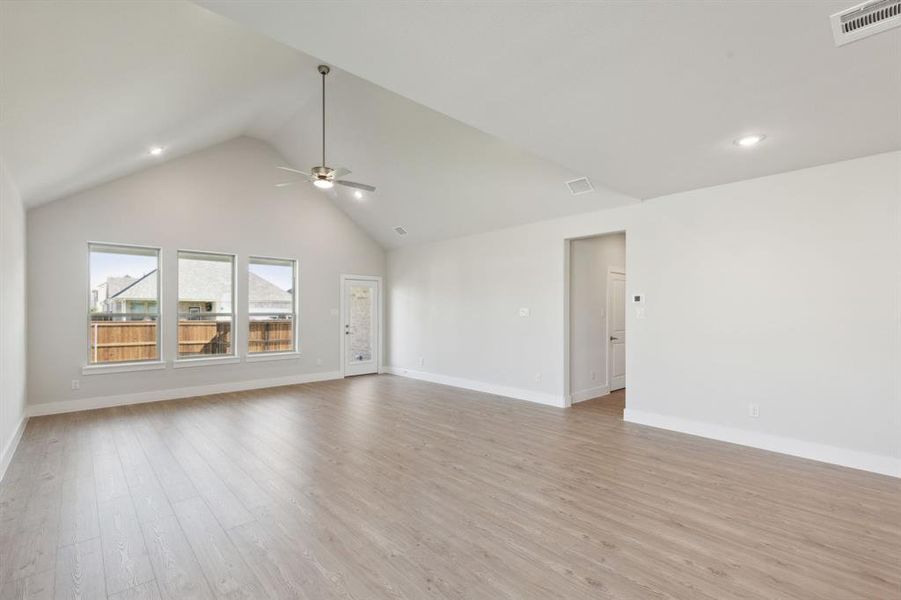 Unfurnished living room featuring high vaulted ceiling, ceiling fan, and light hardwood / wood-style flooring