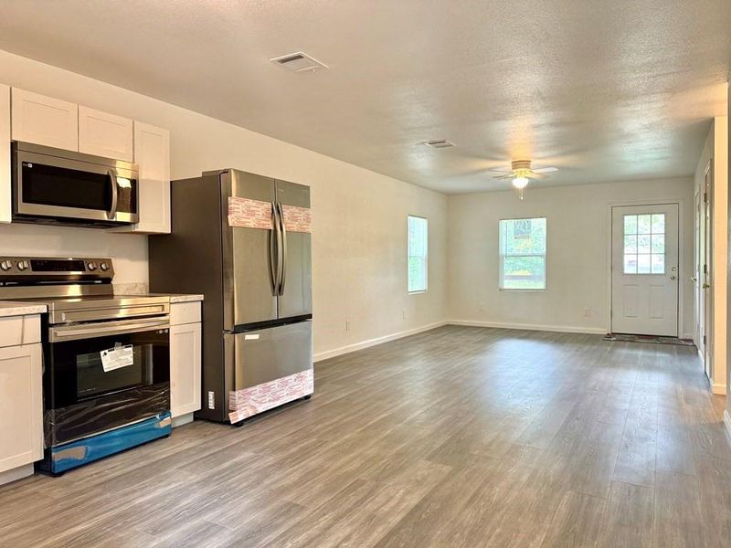 Kitchen featuring appliances with stainless steel finishes, white cabinetry, and light wood-type flooring