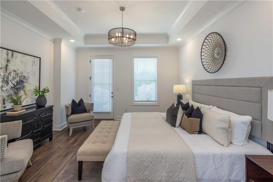 Master Bedroom with ornamental molding, an inviting chandelier, dark hardwood / wood-style floors, and a tray ceilingwith a door leading to a small balcony not the actual unit