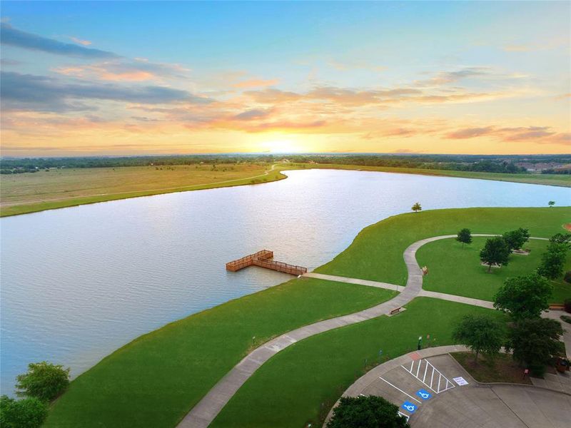 Neighborhood pond. Aerial view at dusk featuring a water view