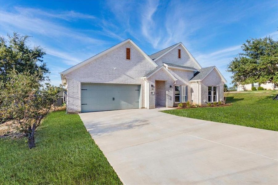 View of front of home featuring a garage and a front yard