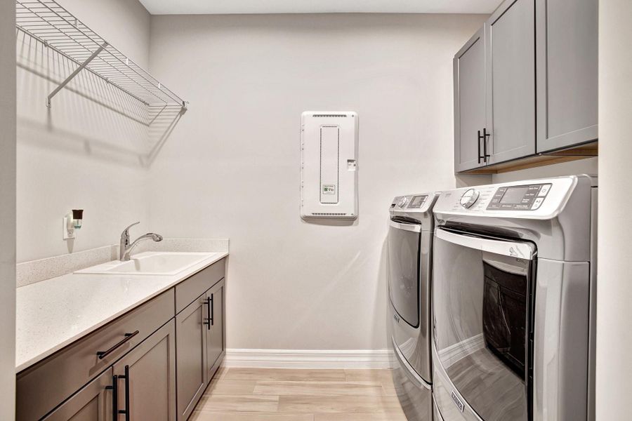 Laundry room with sink and elevated washer and dryer