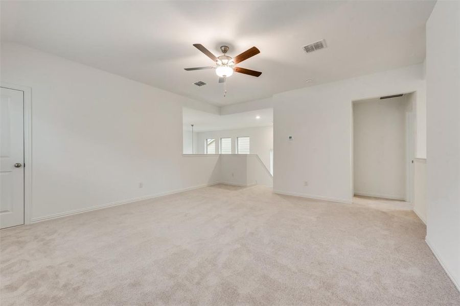 Carpeted empty room with ceiling fan