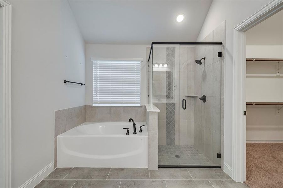 Bathroom with independent shower and bath, tile patterned floors, and vaulted ceiling