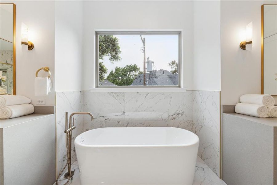 Adjacent to the shower stands a freestanding tub, a symbol of relaxation and indulgence. Surrounded by beautiful stones and finishes, it invites you to immerse yourself in pure luxury as you soak away the cares of the world, surrounded by the tranquility of your private sanctuary.