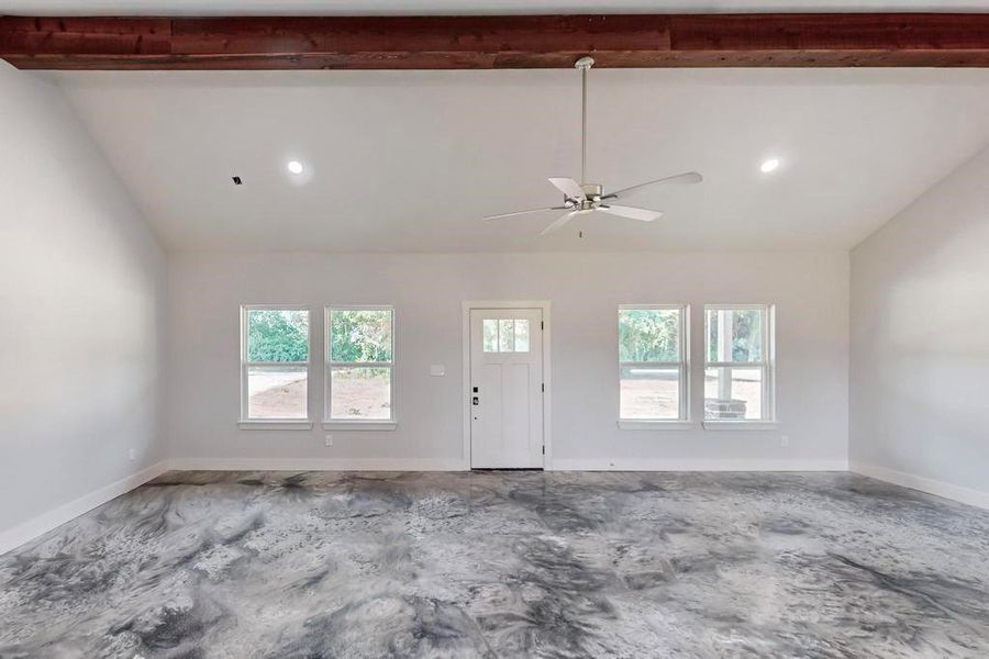 Unfurnished room featuring vaulted ceiling with beams and ceiling fan