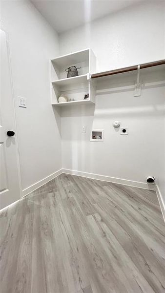 Clothes washing area featuring gas dryer hookup, electric dryer hookup, hardwood / wood-style flooring, and hookup for a washing machine