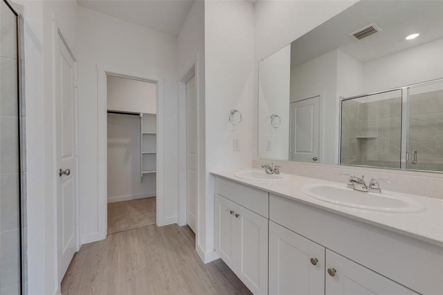 Bathroom featuring hardwood / wood-style floors, an enclosed shower, and vanity