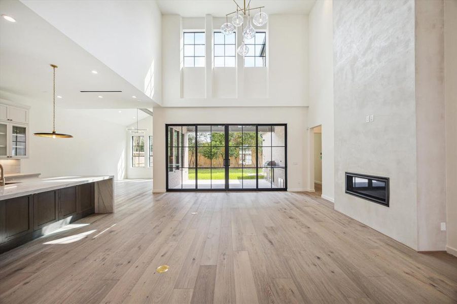 Incredible living room features thoughtful details such as floor plugs, modern fireplace with soaring plaster surround, and beautiful transom windows that allow in even more natural light.