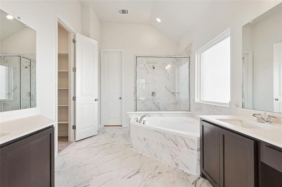 Bathroom featuring vanity, tile patterned floors, lofted ceiling, and shower with separate bathtub