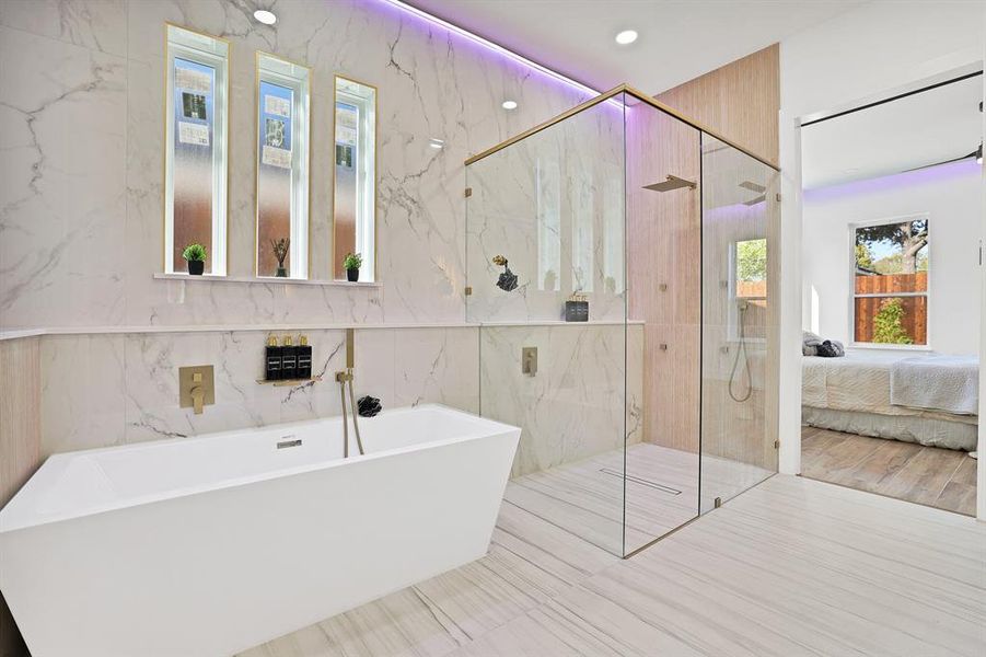 Bathroom featuring hardwood / wood-style flooring, tile walls, and plus walk in shower