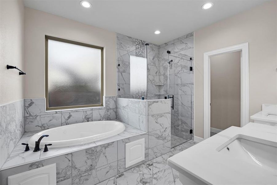 Bathroom featuring vanity and separate shower and tub