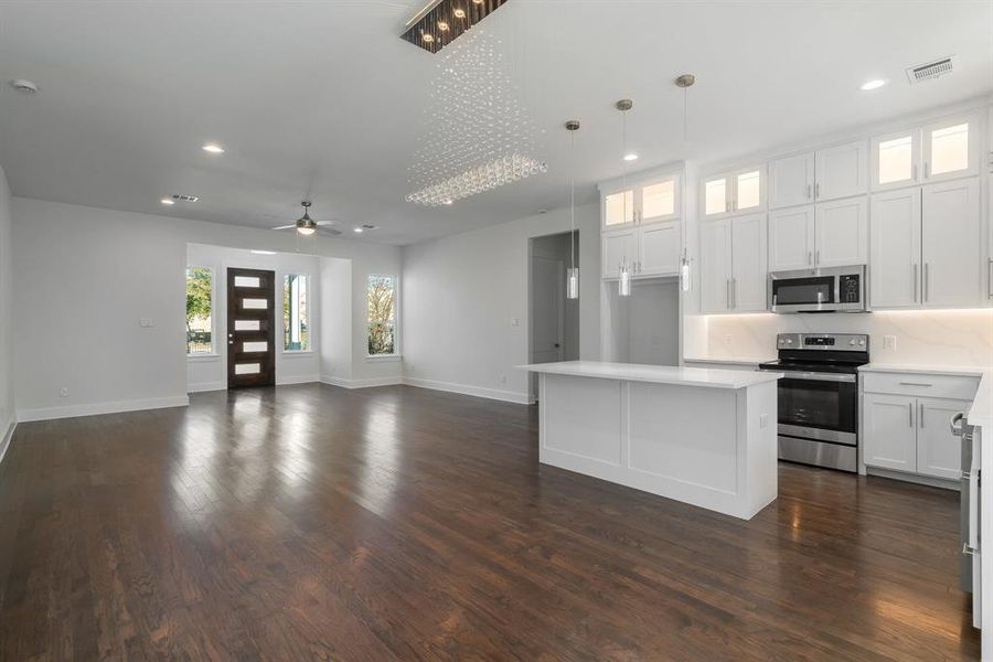 Kitchen featuring appliances with stainless steel finishes, decorative backsplash, white cabinets, and dark hardwood / wood-style floors