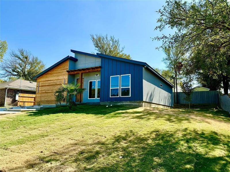 Rear view of property with a yard