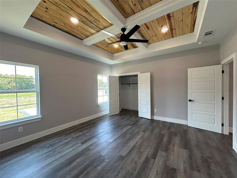 Unfurnished bedroom featuring ceiling fan, a closet, dark wood-type flooring, and multiple windows