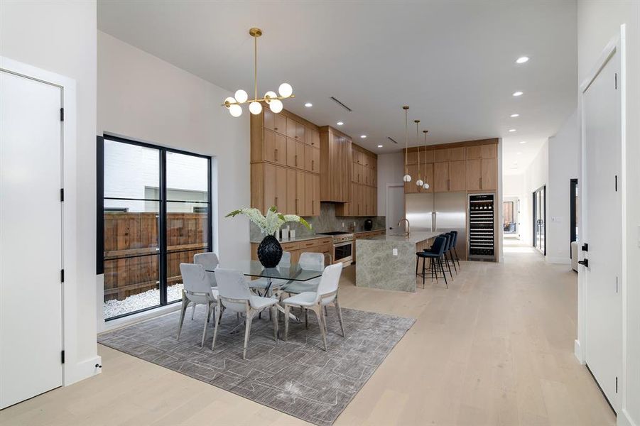 Dining room with sink, plenty of natural light, a chandelier, and light hardwood / wood-style flooring