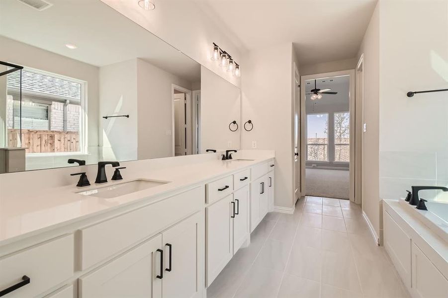 Bathroom featuring vanity, a tub to relax in, tile patterned flooring, and ceiling fan