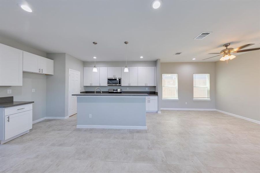 Not only is there room for bar stools, but this kitchen also offers an impressive amount of storage. With double sinks, cleanup is a breeze, making it both practical and stylish.