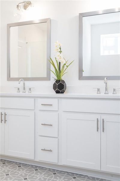 Bathroom with dual  vanity including mirrors, walk in shower with frameless shower door