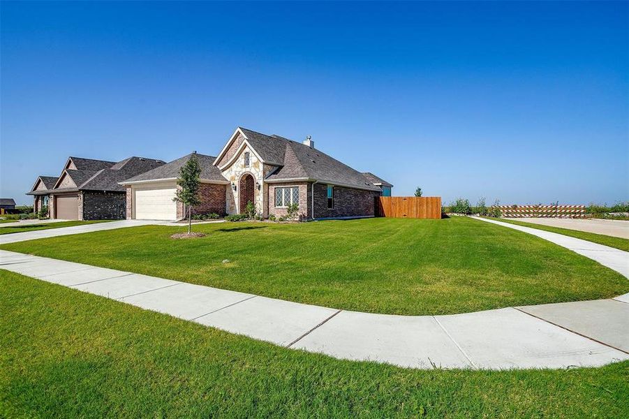 View of front of home with a garage and a front lawn