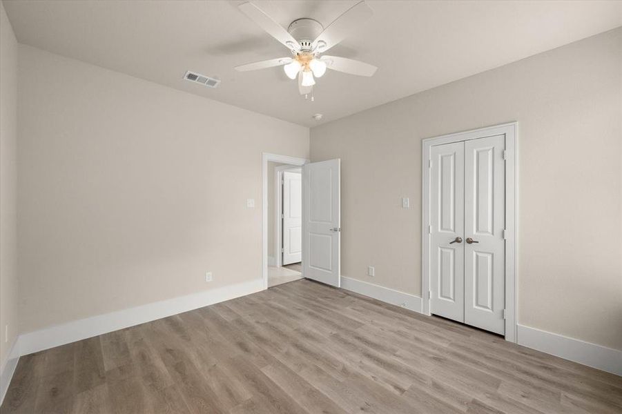 Unfurnished bedroom with light hardwood / wood-style flooring, a closet, and ceiling fan