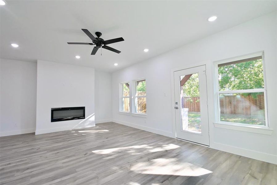 Unfurnished living room featuring light wood-type flooring and ceiling fan