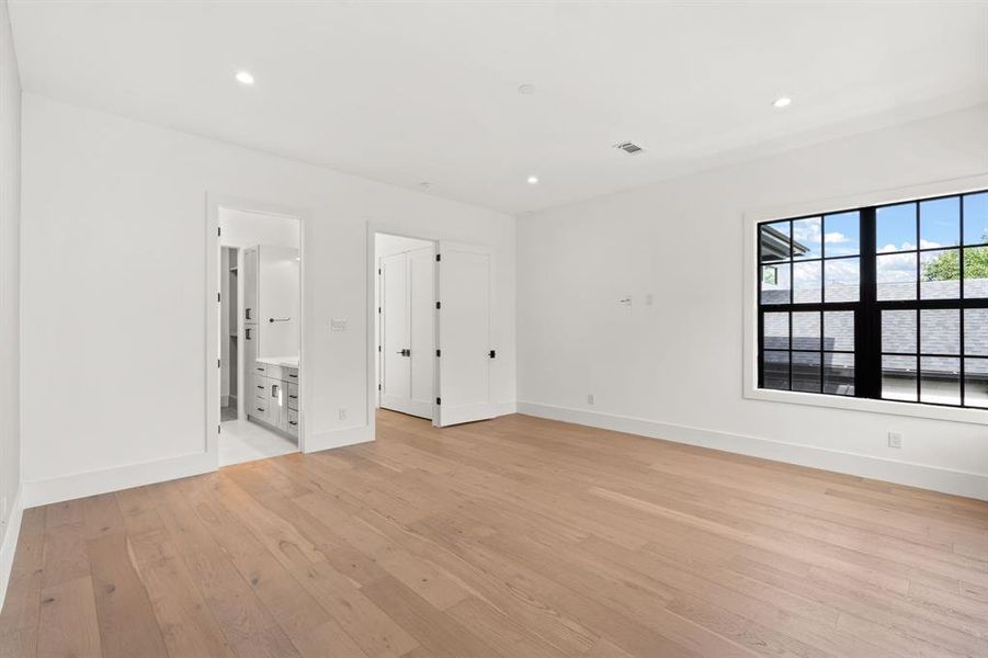 Striking Secondary bedroom features warm hardwood floors, recessed lighting and an en suite bathroom.