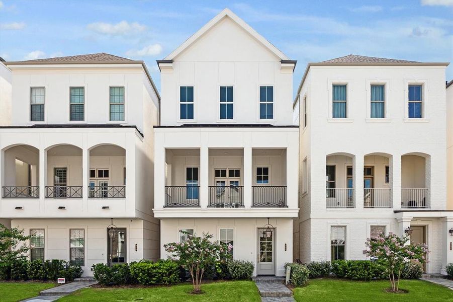 Inside the Guard Gated Houston Community inside the Loop is a 3 story Pelican Builder Built home with an Elevator shaft and outdoor living with green grass in the front of the home