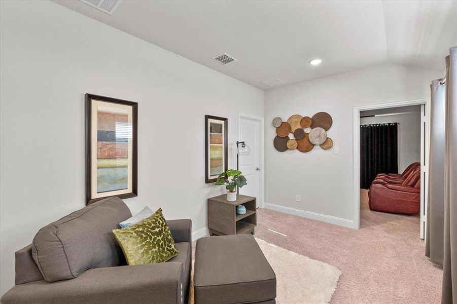 Carpeted living room featuring lofted ceiling